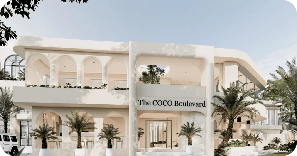 The COCO Boulevard exterior with arched balconies and palms