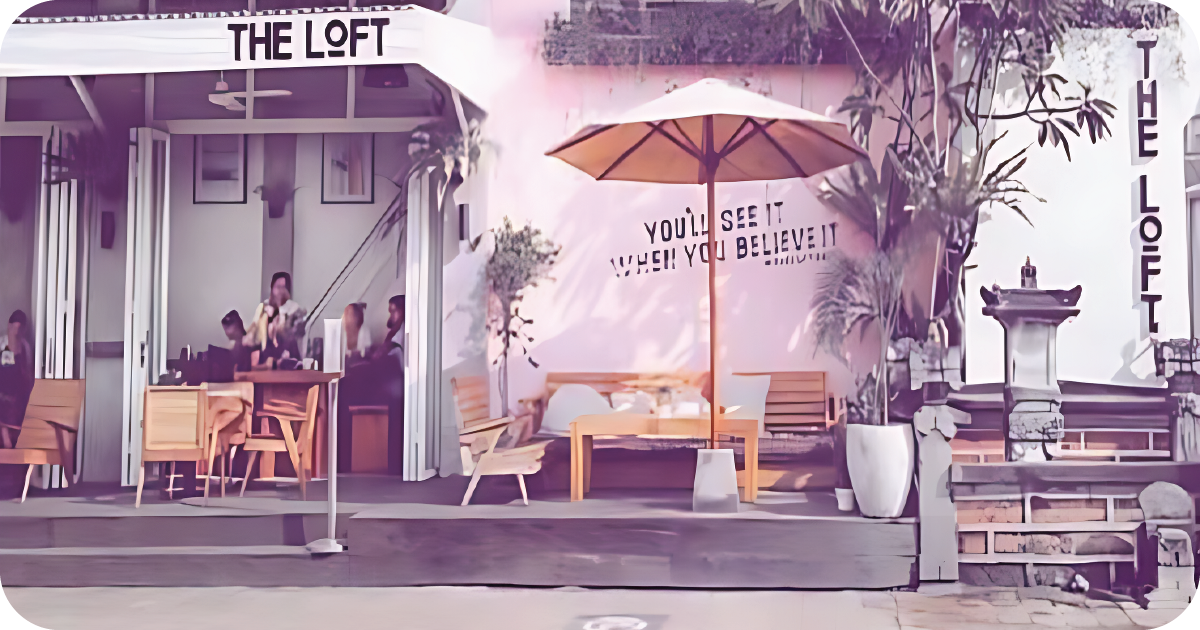 The Loft streetfront patio with umbrella and pink mural