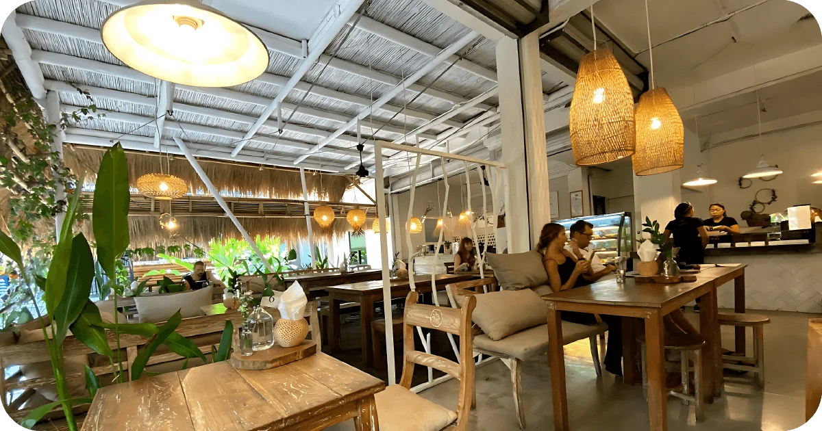Warm rustic interior with rattan lamps, plants, and bakery counter