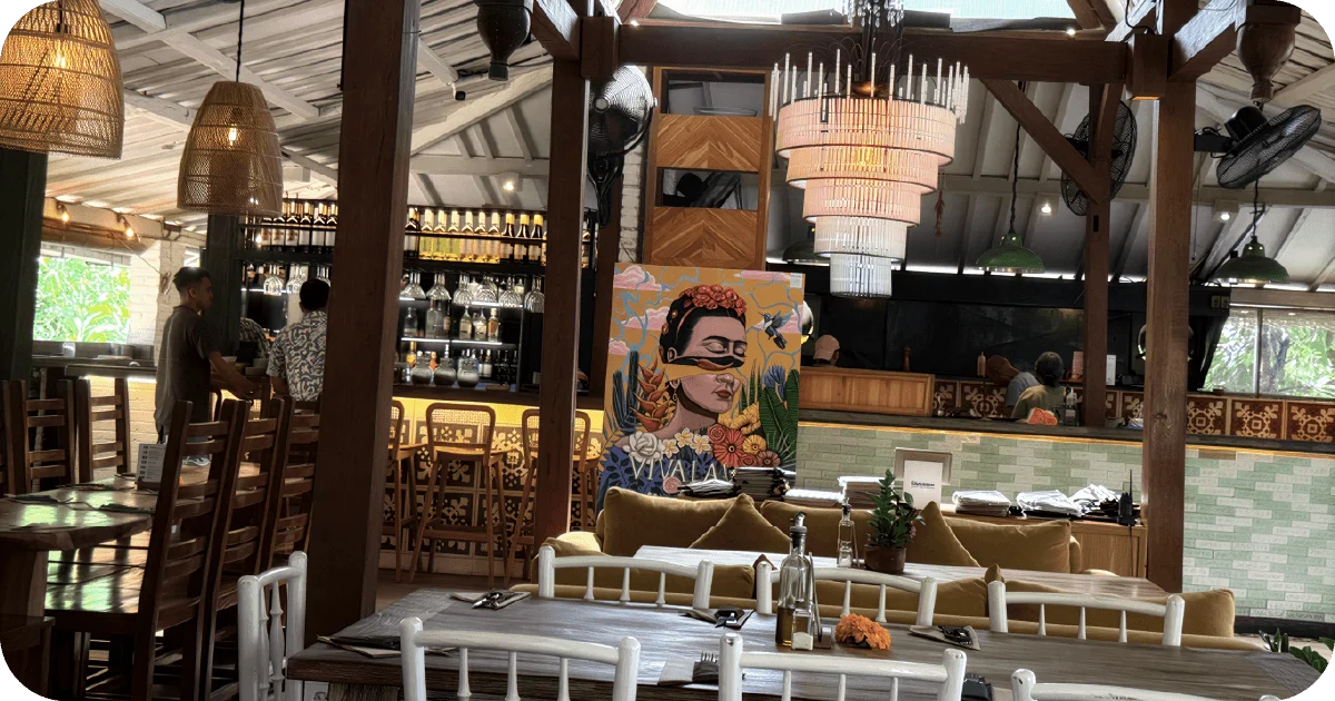 Bar with rattan lamps, chandelier, and colorful mural centerpiece