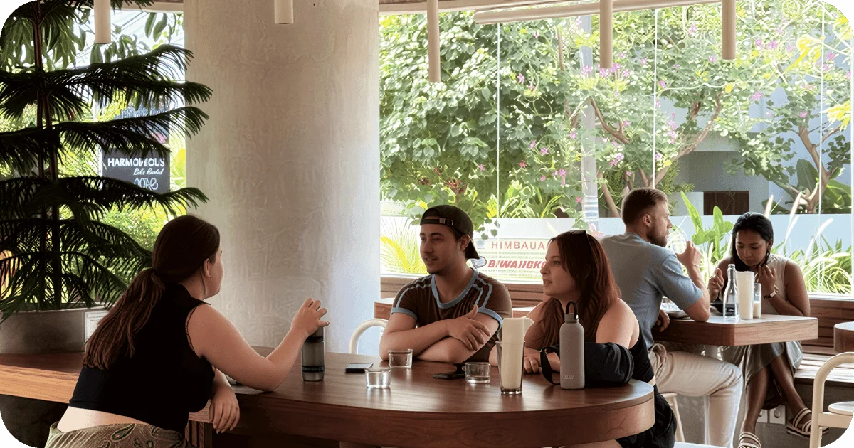 Bright cafe with round wooden tables and floor-to-ceiling windows