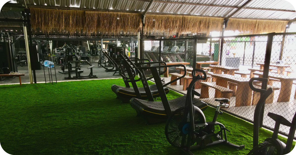 Cardio area with curved treadmills beside seating and weights floor
