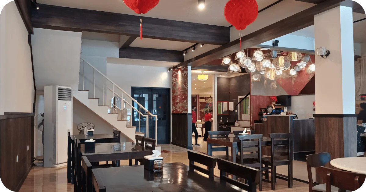 Casual dining area with lantern cluster, dark wood beams, stairs