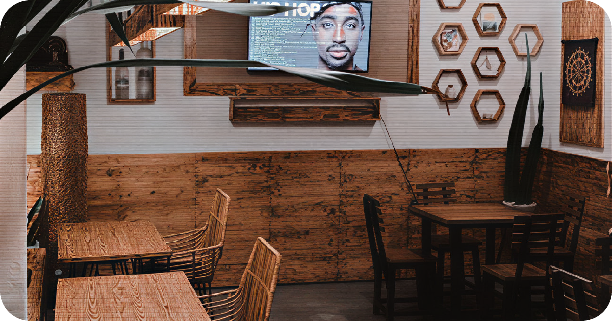 Clean wood-and-white interior with TV, hexagon shelves, and wicker seating