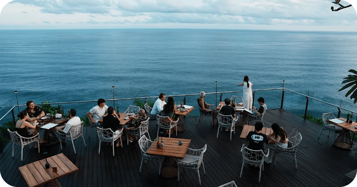 Cliffside deck seating with ocean panorama and wicker chairs