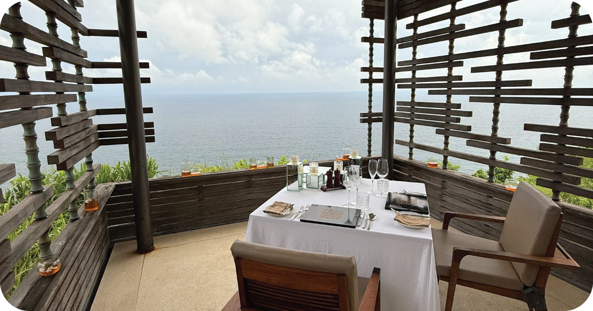 Cliffside pavilion table with white linens and ocean view