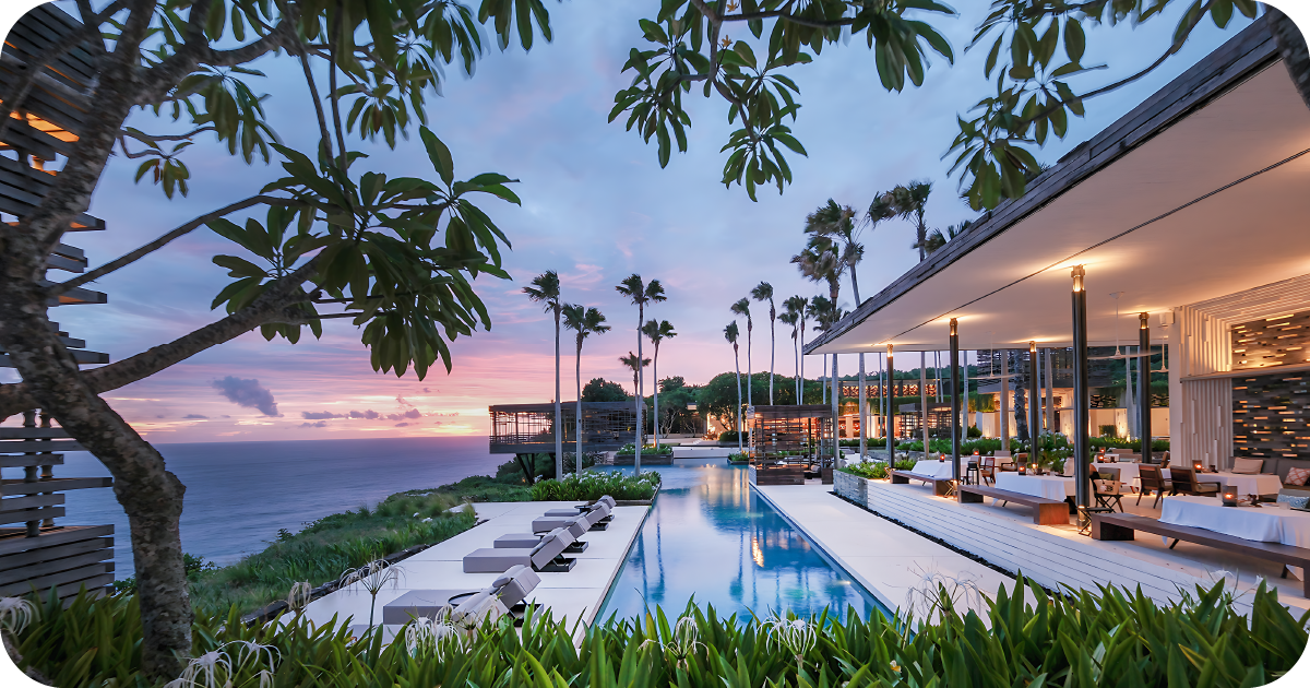 Cliffside poolside restaurant terrace at dusk with ocean views