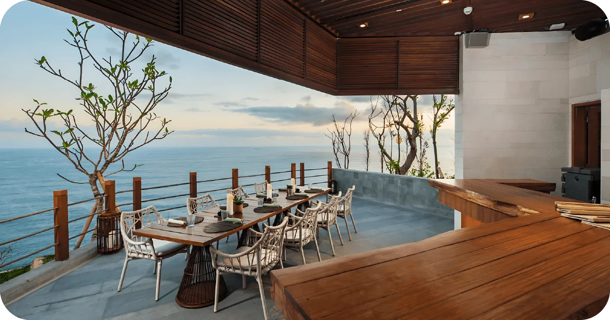 Covered cliffside terrace with long communal table and ocean view
