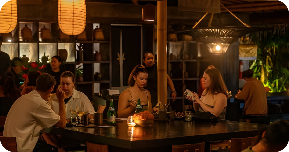 Dimly lit dining room with paper lanterns and communal tables