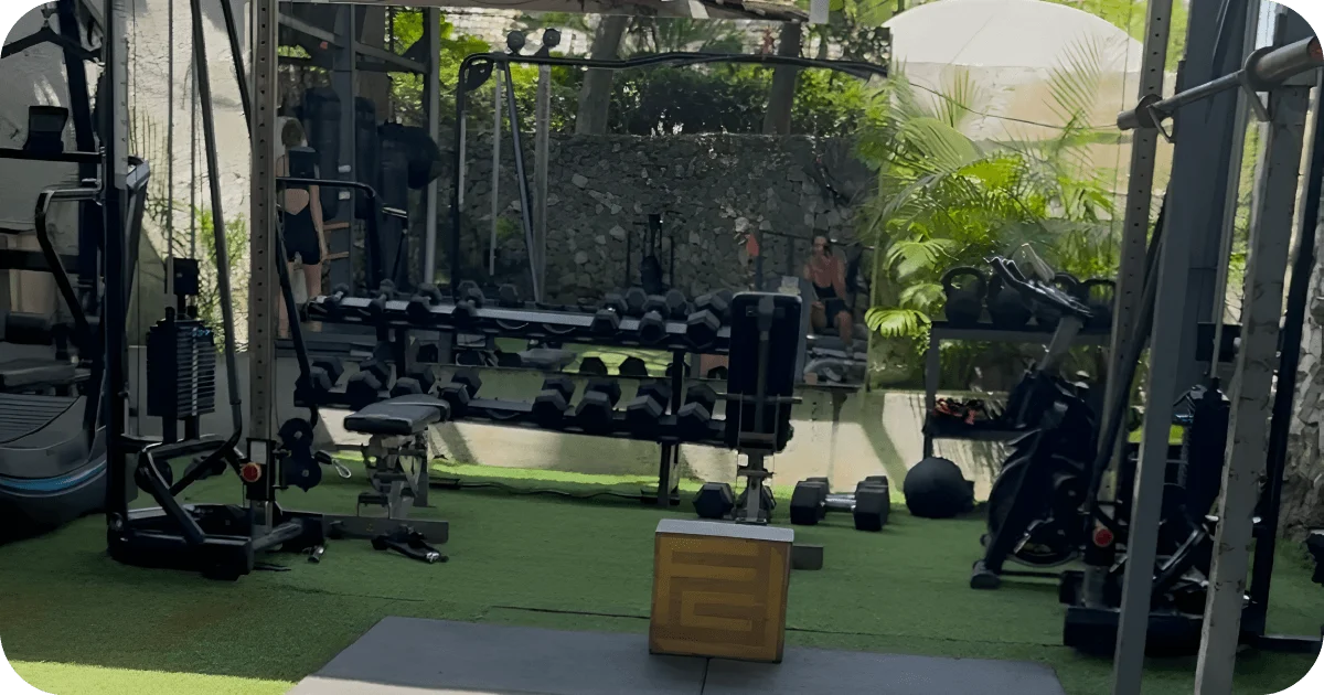 Dumbbell rack, kettlebells, and mirrors in garden-view gym area
