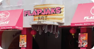 Flapjaks Bali exterior sign with pancake stack and pink awnings