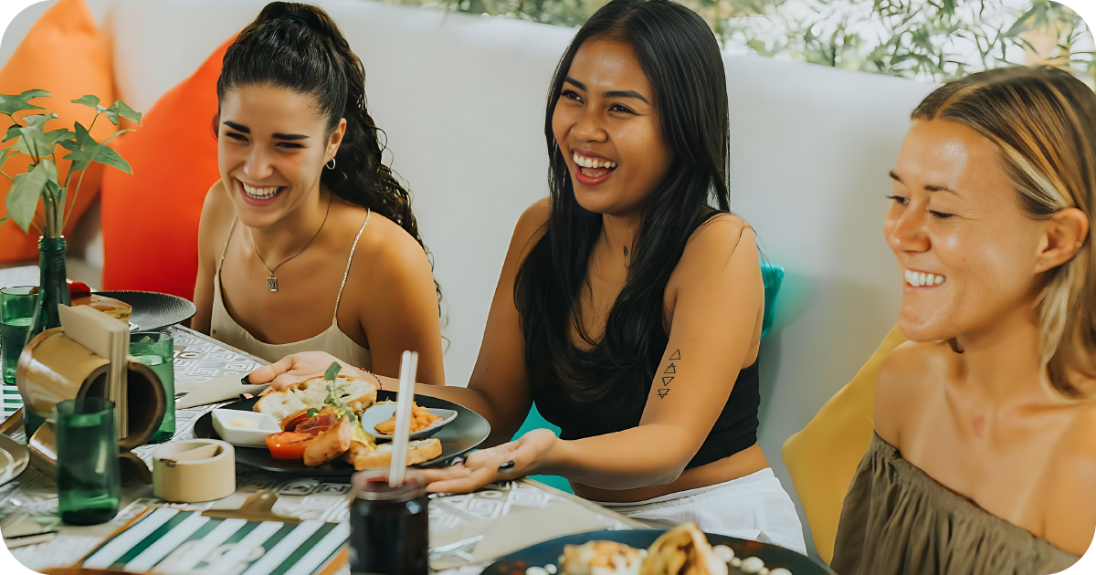 Friends eating meals at cafe table after workout