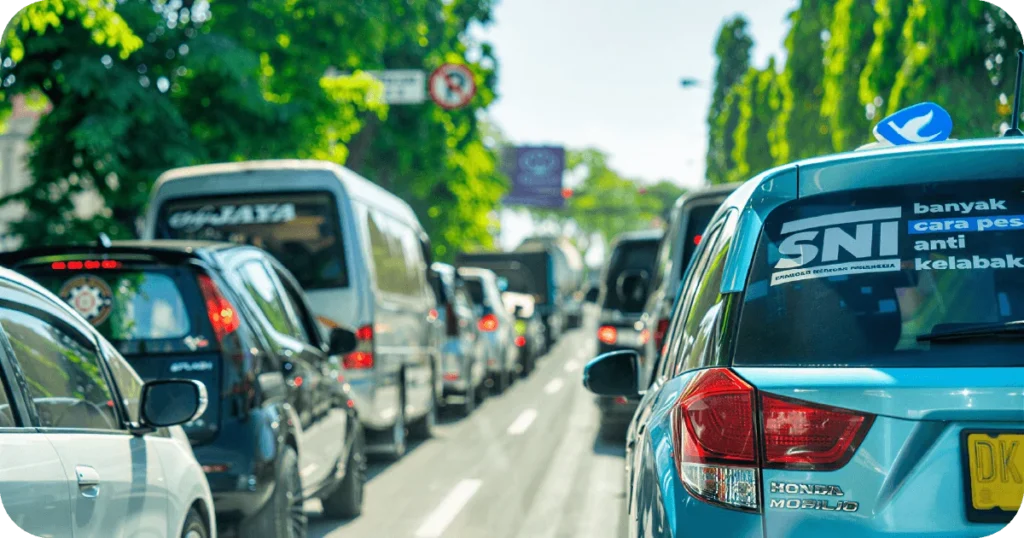 Best Bali Transport App: Heavy traffic on a tree-lined city street