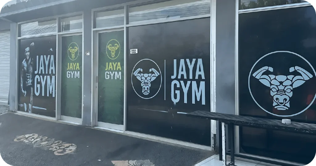 Jaya Gym entrance with large window decals and open sign
