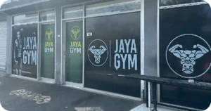Jaya Gym entrance with large window decals and open sign