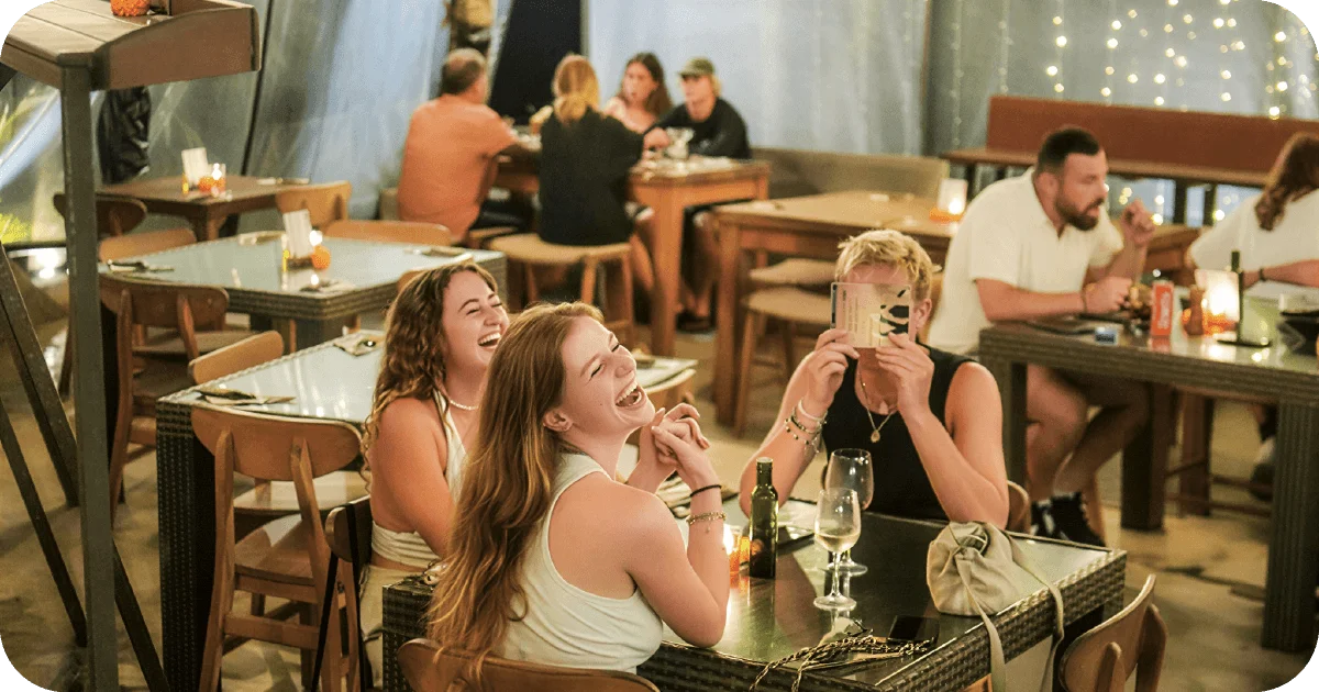 Lively dining room with candles, wooden chairs, and wine glasses