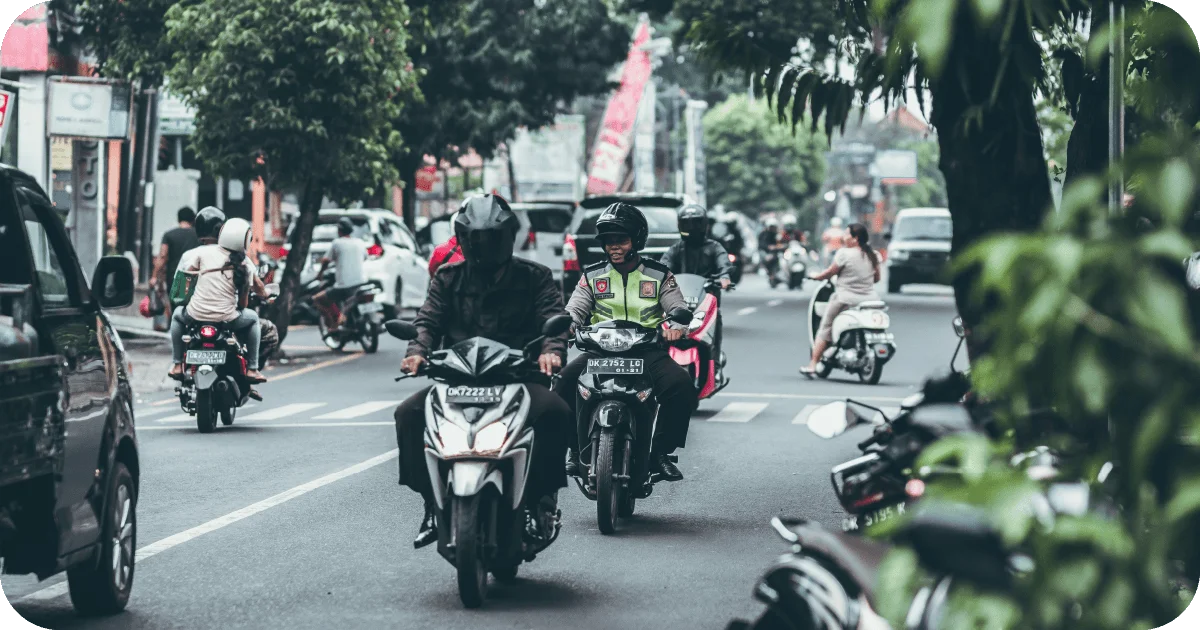 Motorbikes weaving through busy urban street traffic