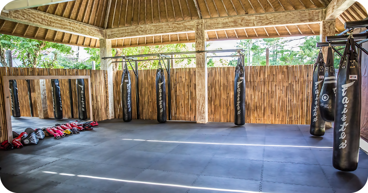 Open-air bag area with Fairtex heavy bags, gloves and bamboo walls