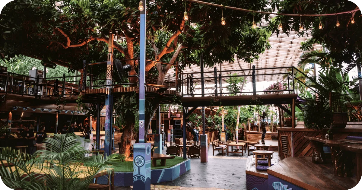 Open-air bar with massive tree, mezzanine walkways, lounge seating
