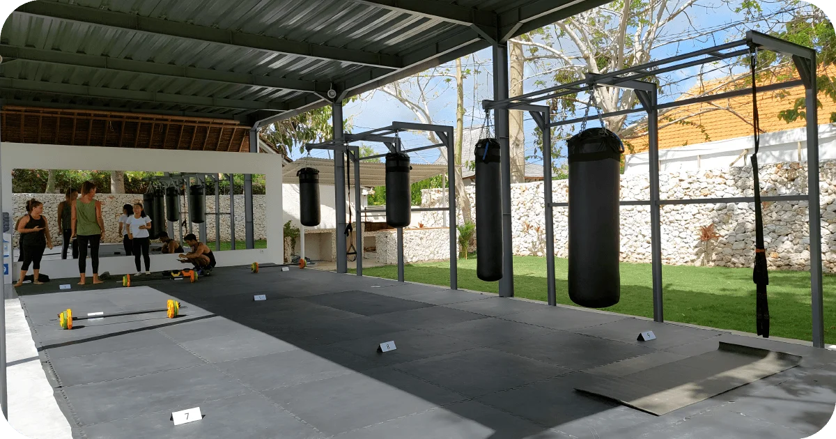 Open-air boxing zone with heavy bags and numbered workout stations