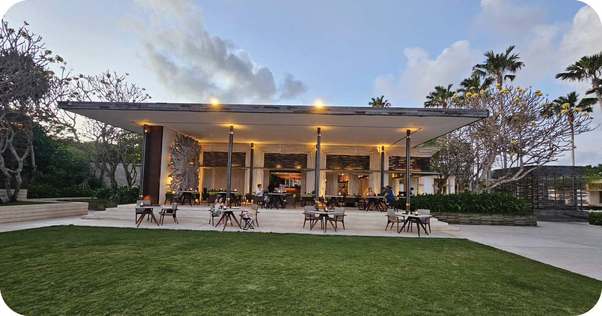 Open-air restaurant with lit canopy and lawn terrace seating