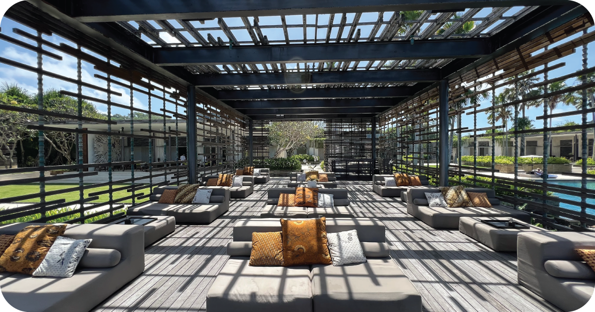 Outdoor lounge seating with daybeds under slatted pergola by pool