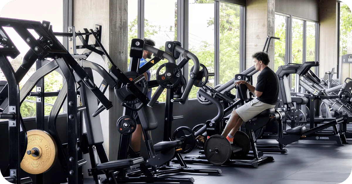 Surya Gym Bali: The Ultimate Review of Canggu's Premier Fitness Destination 3 Plate-loaded strength machines by windows with member training