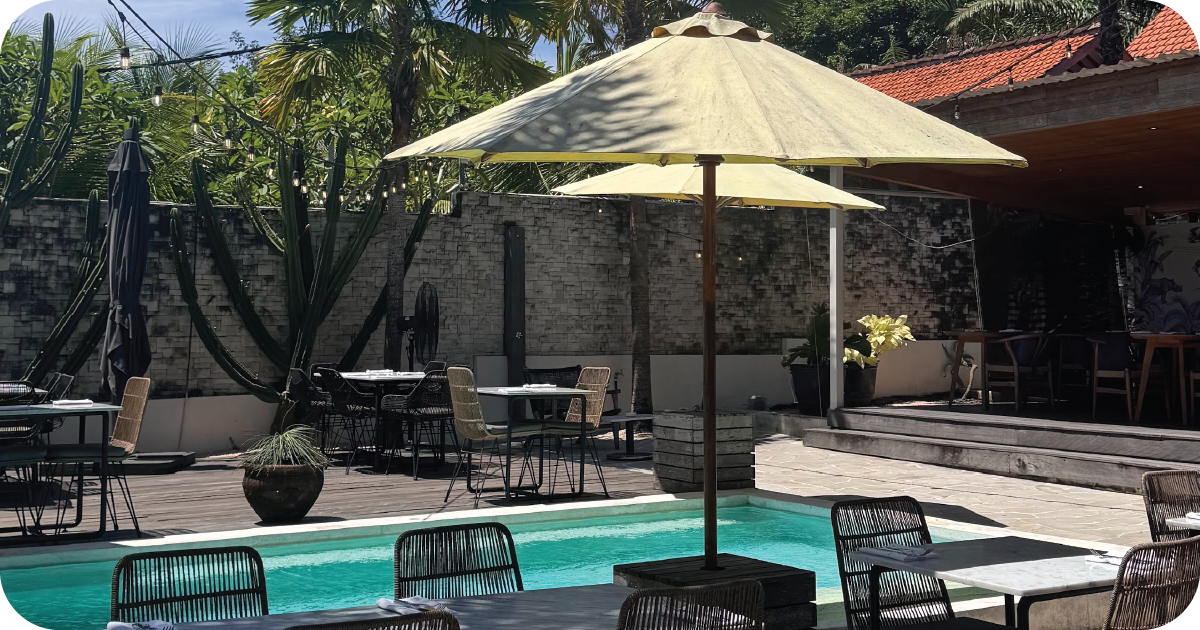 Poolside courtyard seating with umbrellas, bar counter, and cacti