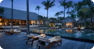 Resort pool deck at dusk with loungers and candlelit tables
