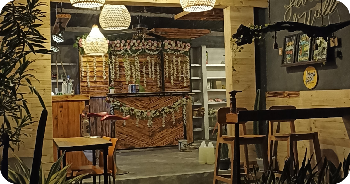 Rustic wood bar with floral garlands, pendant lights, and red bar stools