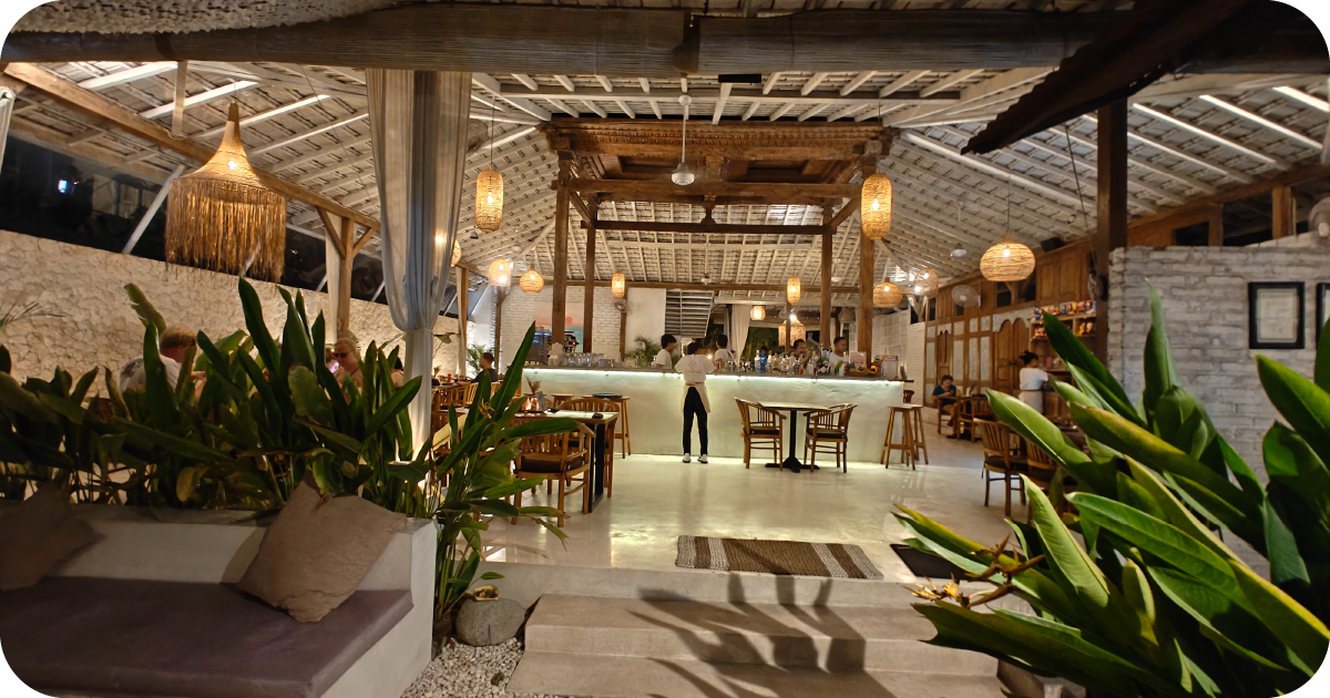 Spacious open-air dining room with woven pendant lights and illuminated bar