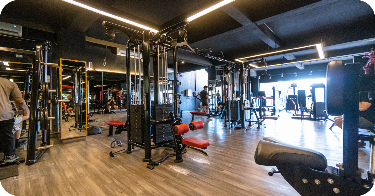 Spacious strength area with cable stations, benches, mirrors and wood flooring