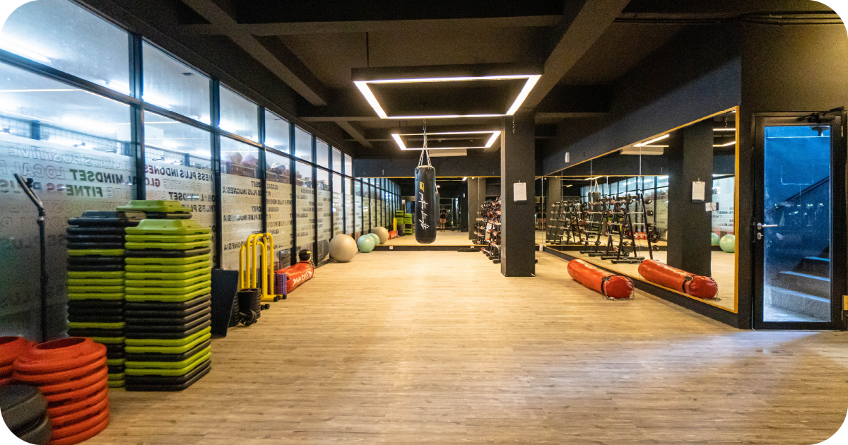 Spacious studio with boxing bag, step stacks, mirrors and racks