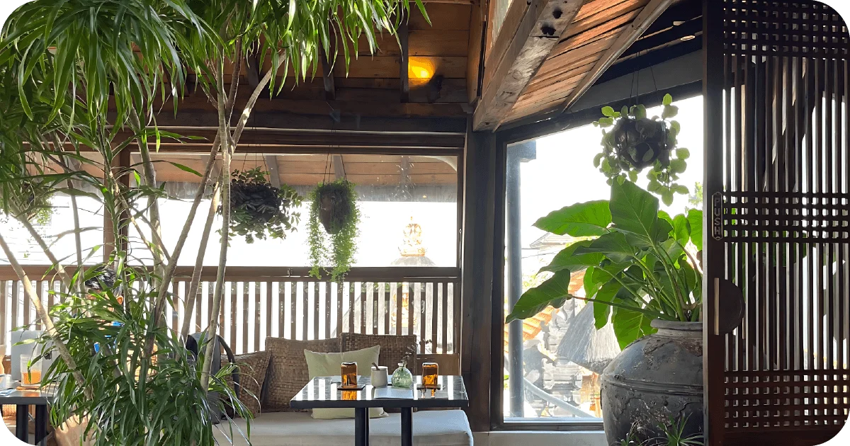 Sunlit lounge seating with lush plants and balcony view