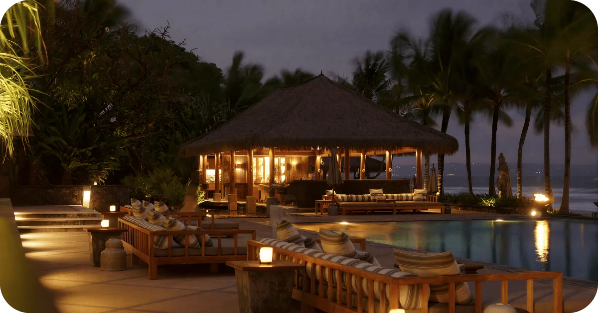 Thatched-roof pool bar with cushioned benches and candlelit tables