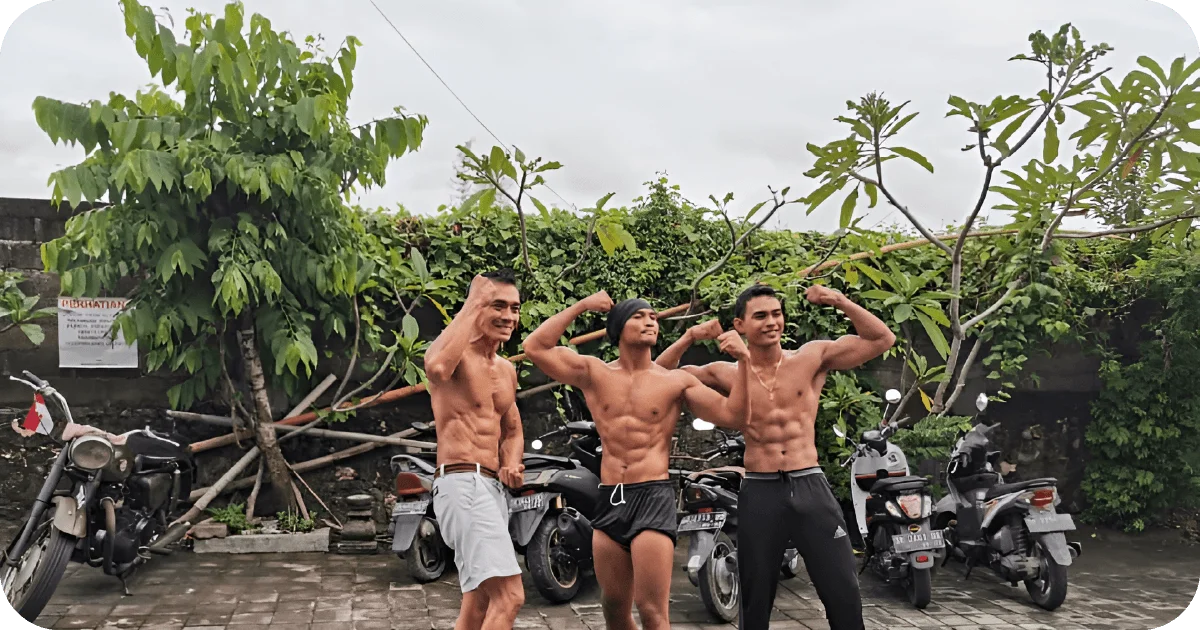 Three people flexing outside by parked motorbikes and trees