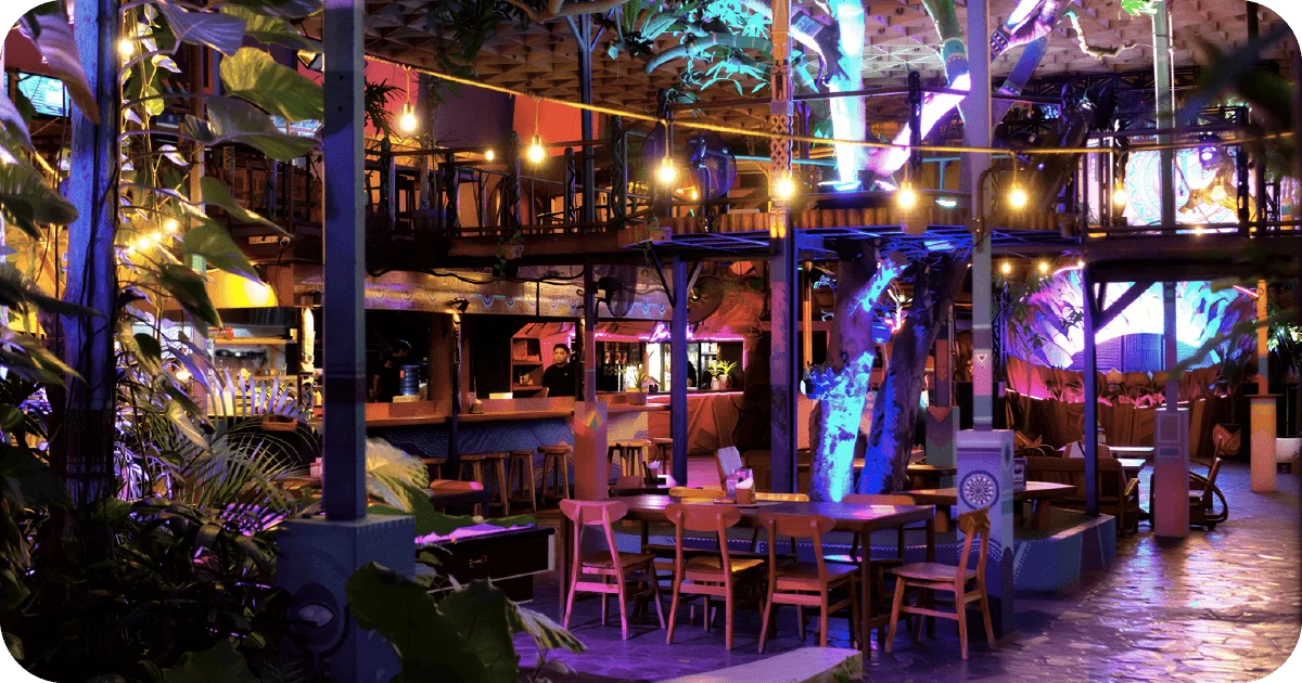 Two-level jungle-themed bar with string lights and neon glow