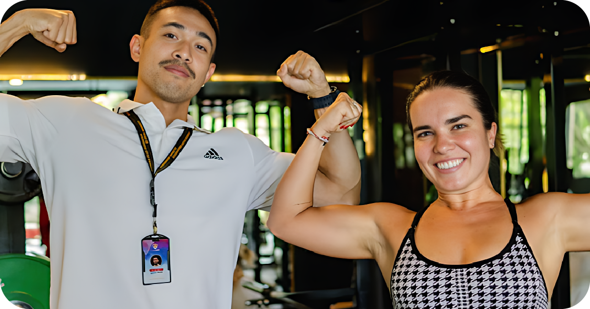 Two members flexing biceps inside weight room