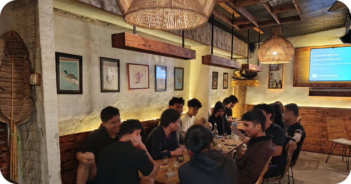 Warm interior with wicker pendants, framed art, and a packed communal table