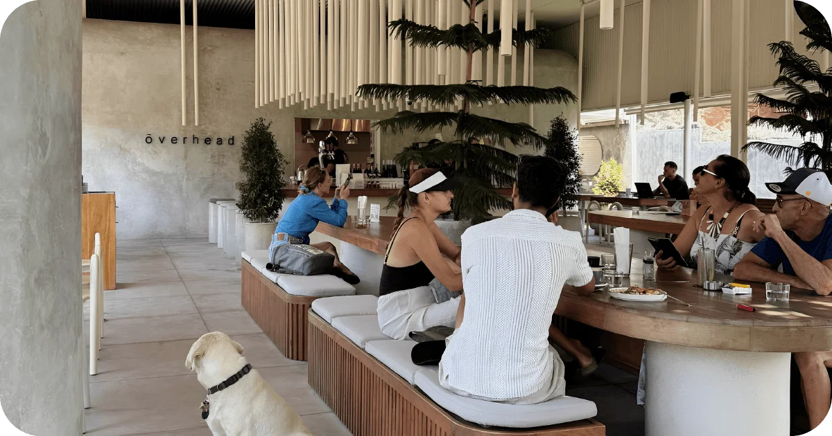 ōverhead busy communal seating with cushion benches and pendant tube fixtures